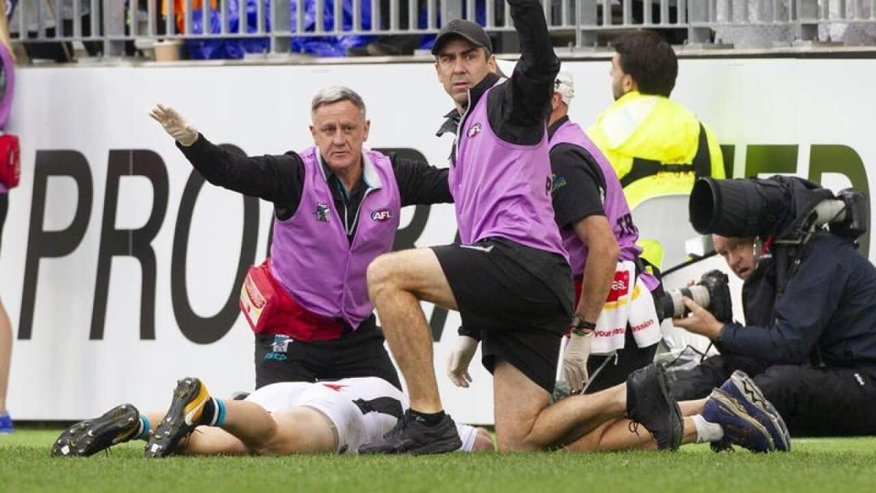 Robbie Gray of Port Adelaide is collapsed on the ground.