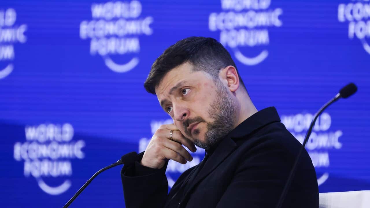 Close up of Volodymr Zelenskyy in front of World Economic Forum brand backdrop