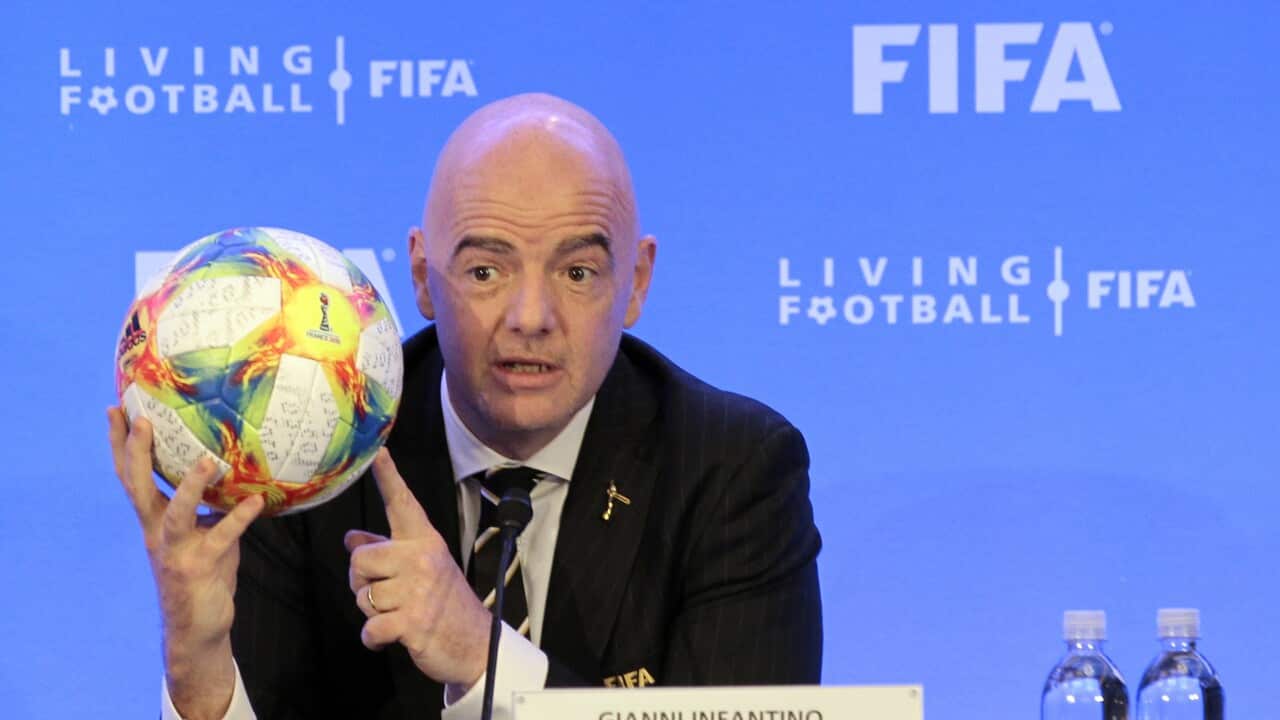 FIFA President Gianni Infantino holds a football.