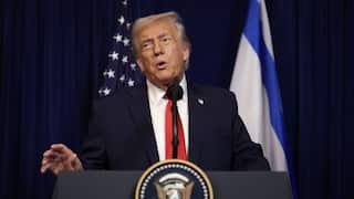 Donald Trump speaks from a podium featuring the presidential seal, positioned between the American and Israeli flags.