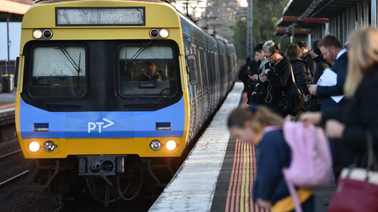 Commuters wait for a city loop train at Newmarket Station