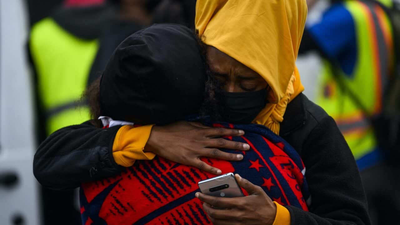 Two people embrace as demonstrators gather in Brooklyn Center, Minnesota after 20 year old Daunte Wright was shot and killed during a traffic stop.
