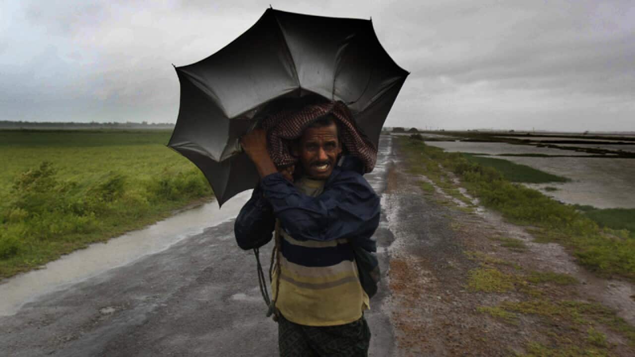 An Indian villager braving strong winds, in village Podampeta, Ganjam