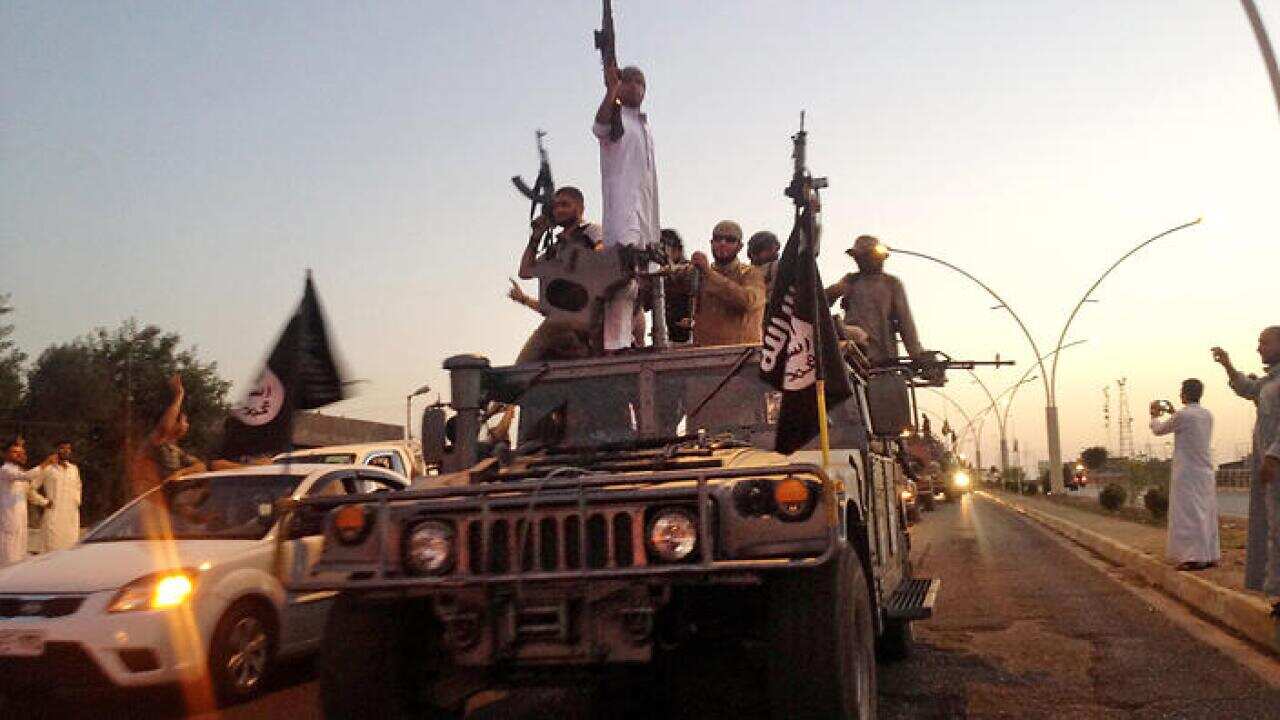 Fighters from the Islamic State group parade in a commandeered Iraqi security forces armored vehicle down a main road at the northern city of Mosul, Iraq. (File: AAP)