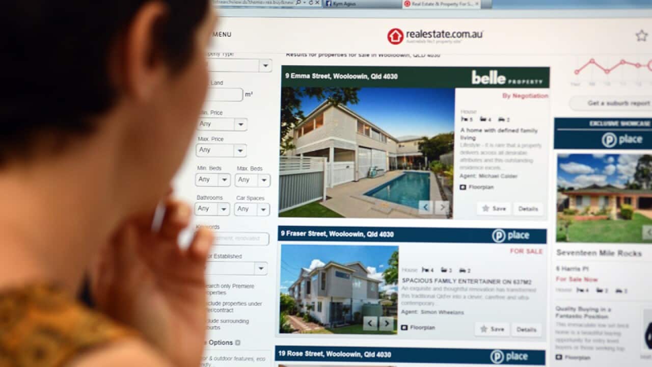 A woman looks at real estate advertising in Brisbane
