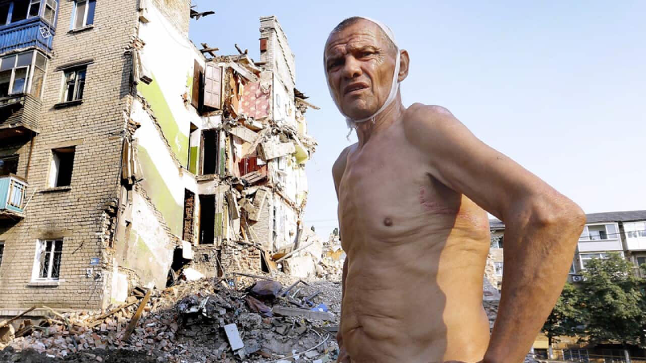 A man in front of his destroyed house