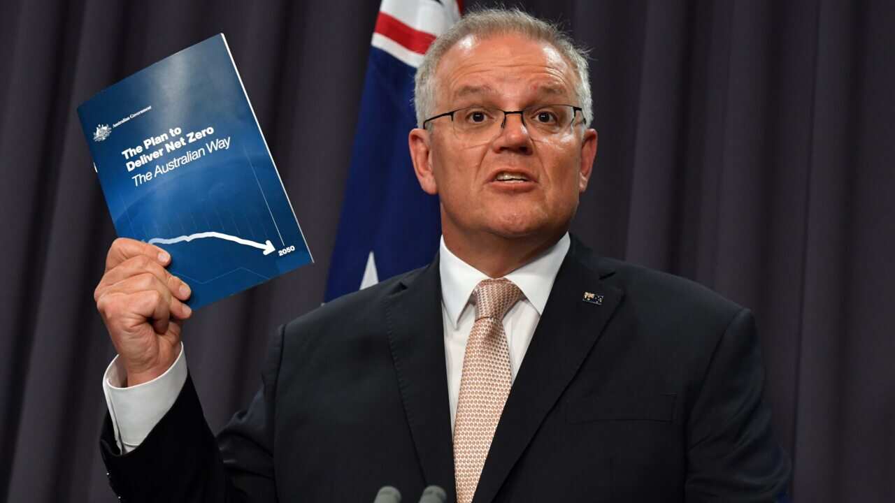 Mr Morrison holds a document outlining his net zero emissions plan.