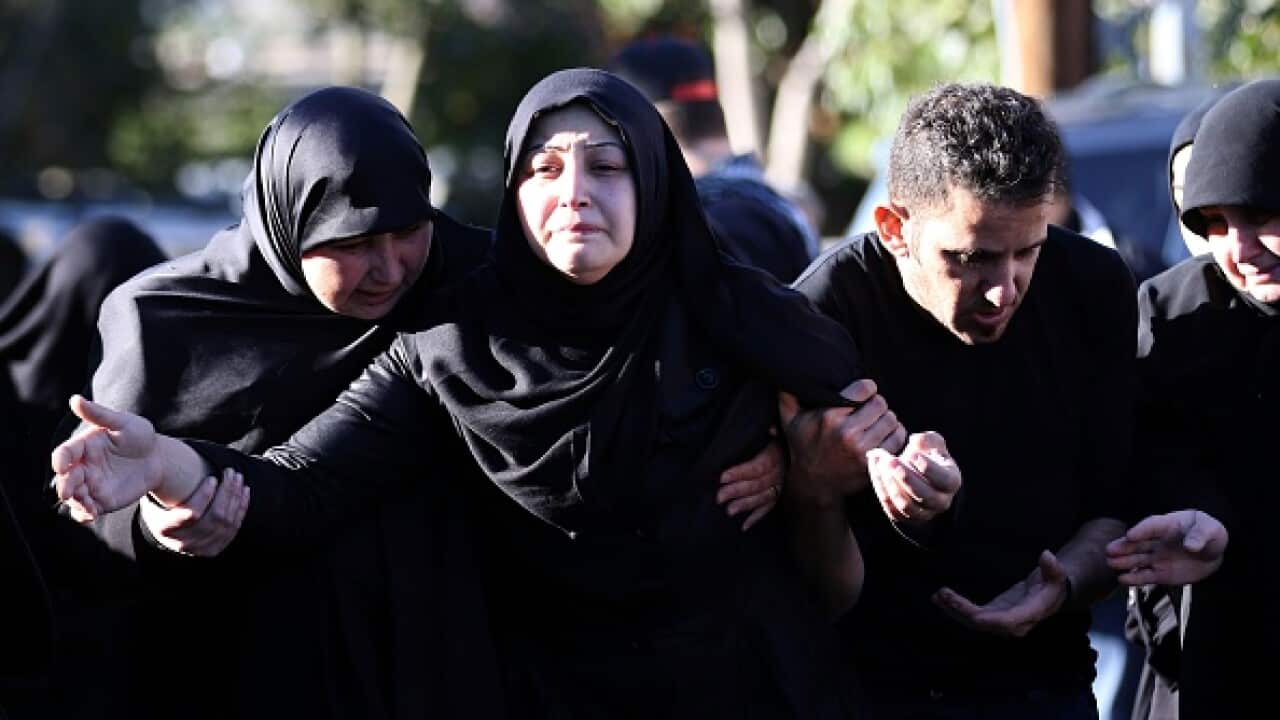The wife (C) of Adel Termos, who was killed in a twin bombing attack that rocked a busy shopping street in the area of Burj al-Barajneh in Beirut's southern suburb, mourns during his funeral in the village of Tallussa in the Nabatiyeh governorate, south o