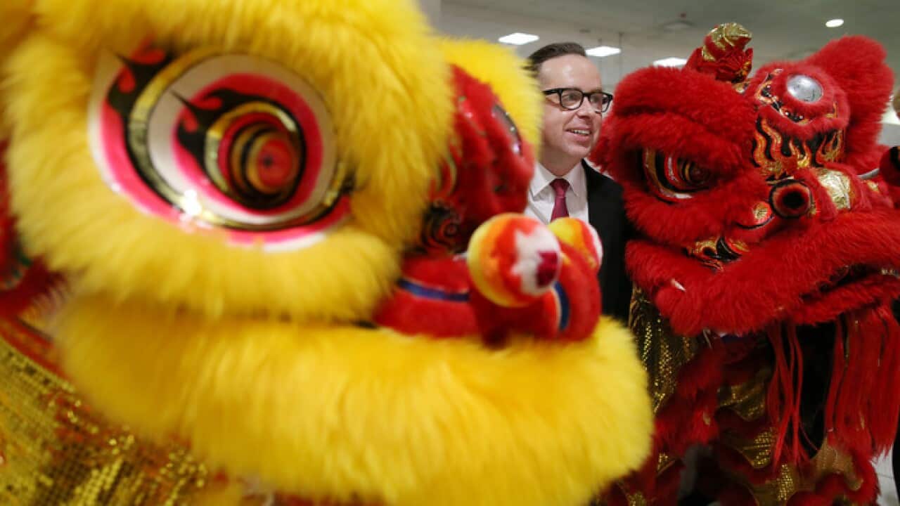 Qantas CEO Alan Joyce poses with two Chinese Lion dancers in Sydney International Airport.