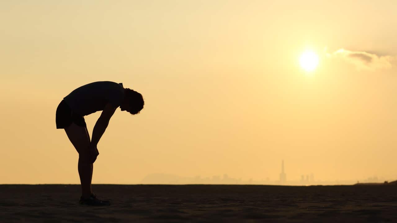 Silhouette of an exhausted sportsman at sunset