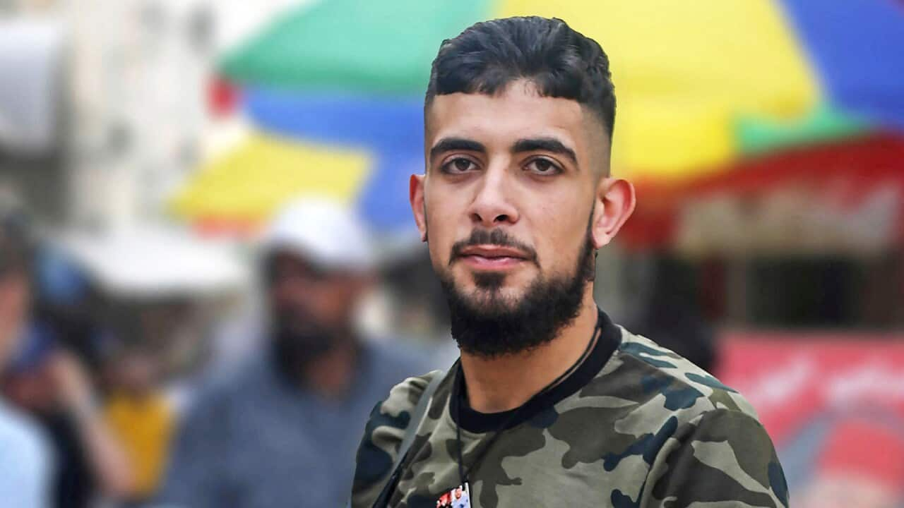 A young man with a beard in a khaki t-shirt 