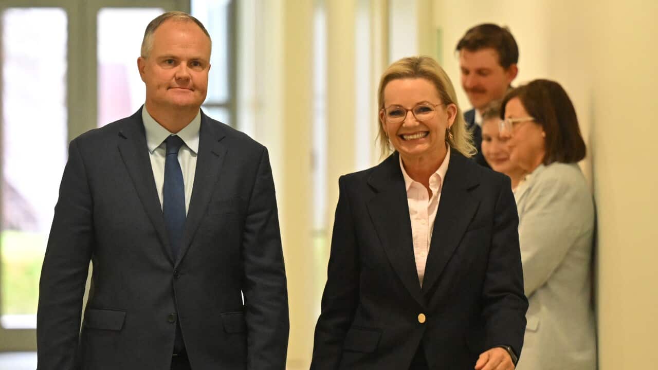 A man and a woman walking down a hall