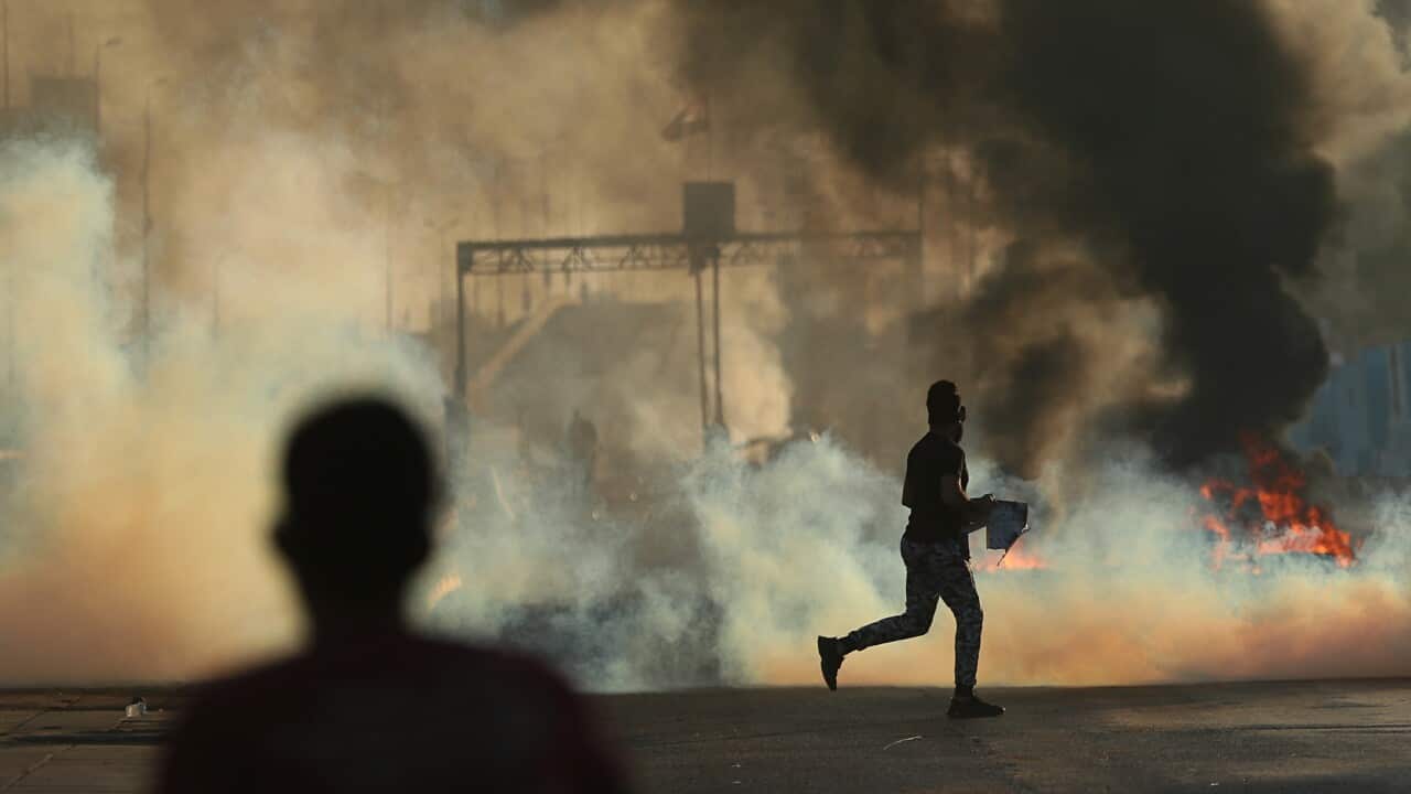 Anti-government protesters set fires and close a street during a demonstration in Baghdad.