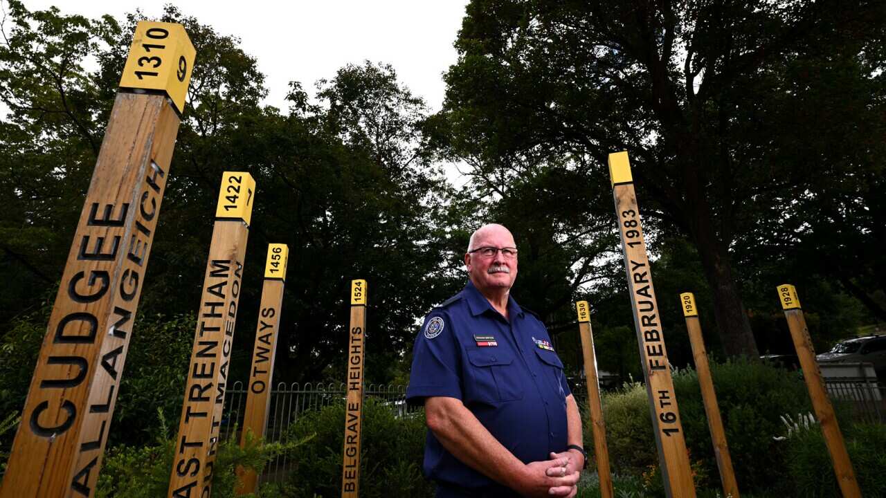 Former Cockatoo fire brigade captain poses with the Ash Wednesday memorial (AAP).jpg