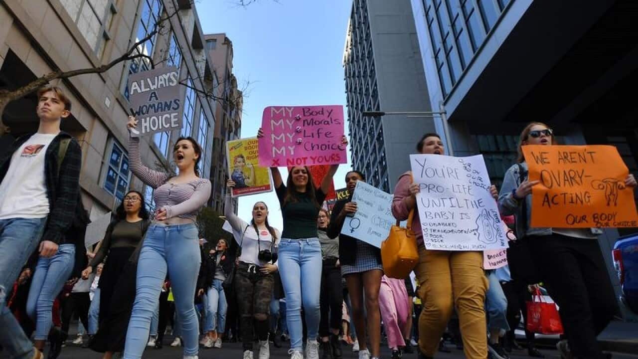 Protesters hold placards during the Our Body Our Choice march
