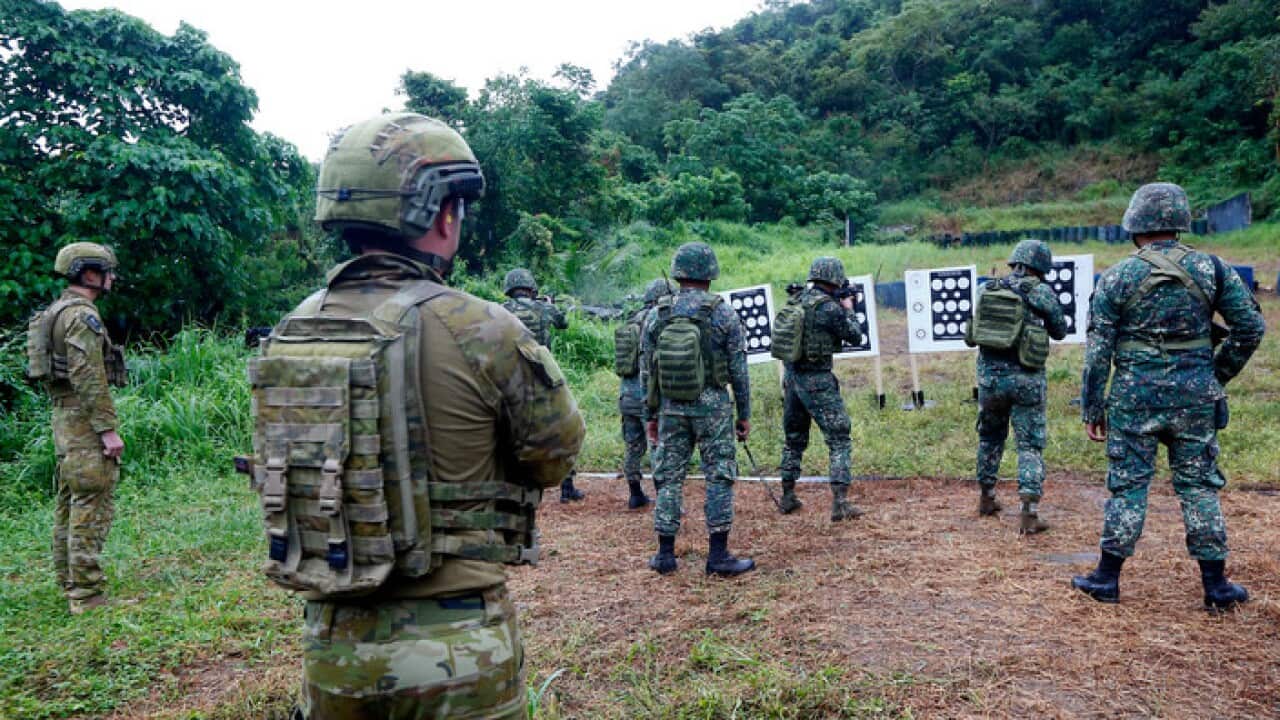Members of the Australian Defense Forces watch as Philippine Marines fire at their targets
