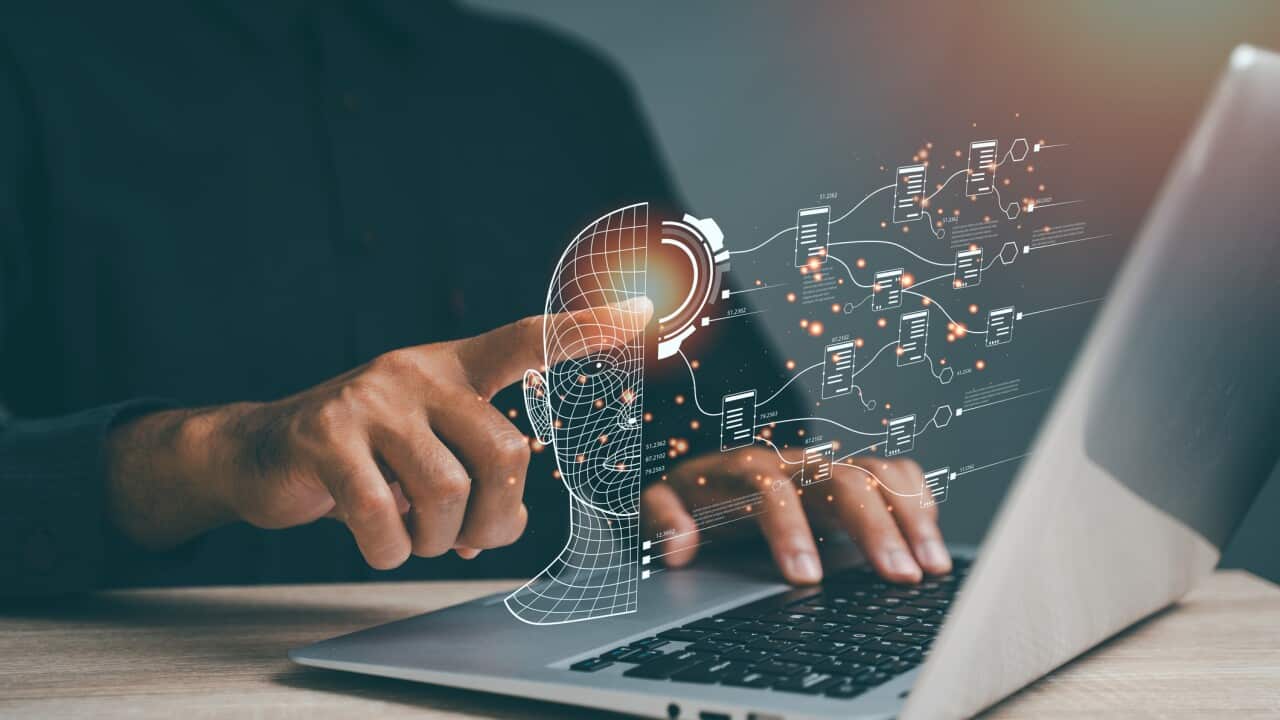 A person is using a laptop to draw a brain