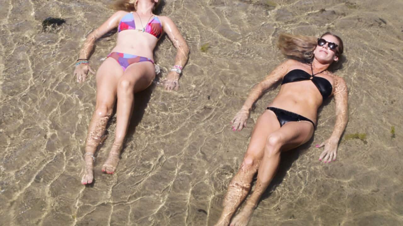 Two women cool off at St Kilda beach during heatwave conditions