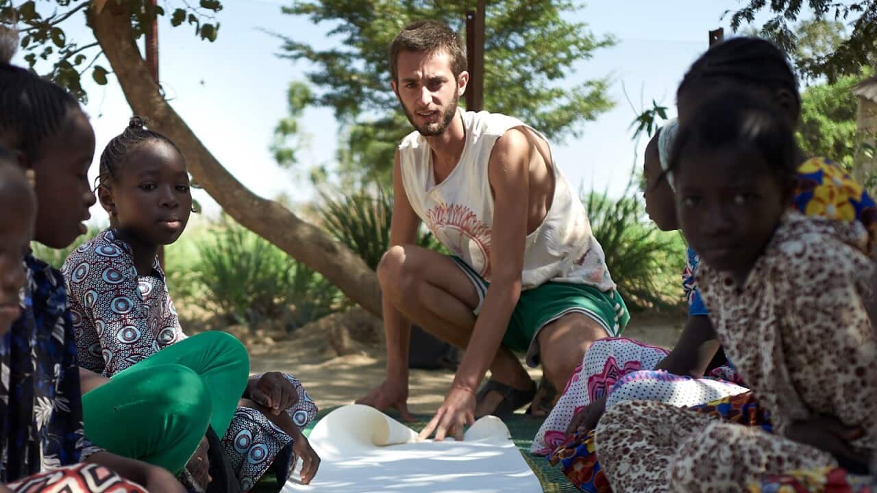Tommaso Sandri con il suo rotolo di 30 metri di disegni e messaggi a Bamako, Mali, 2019.