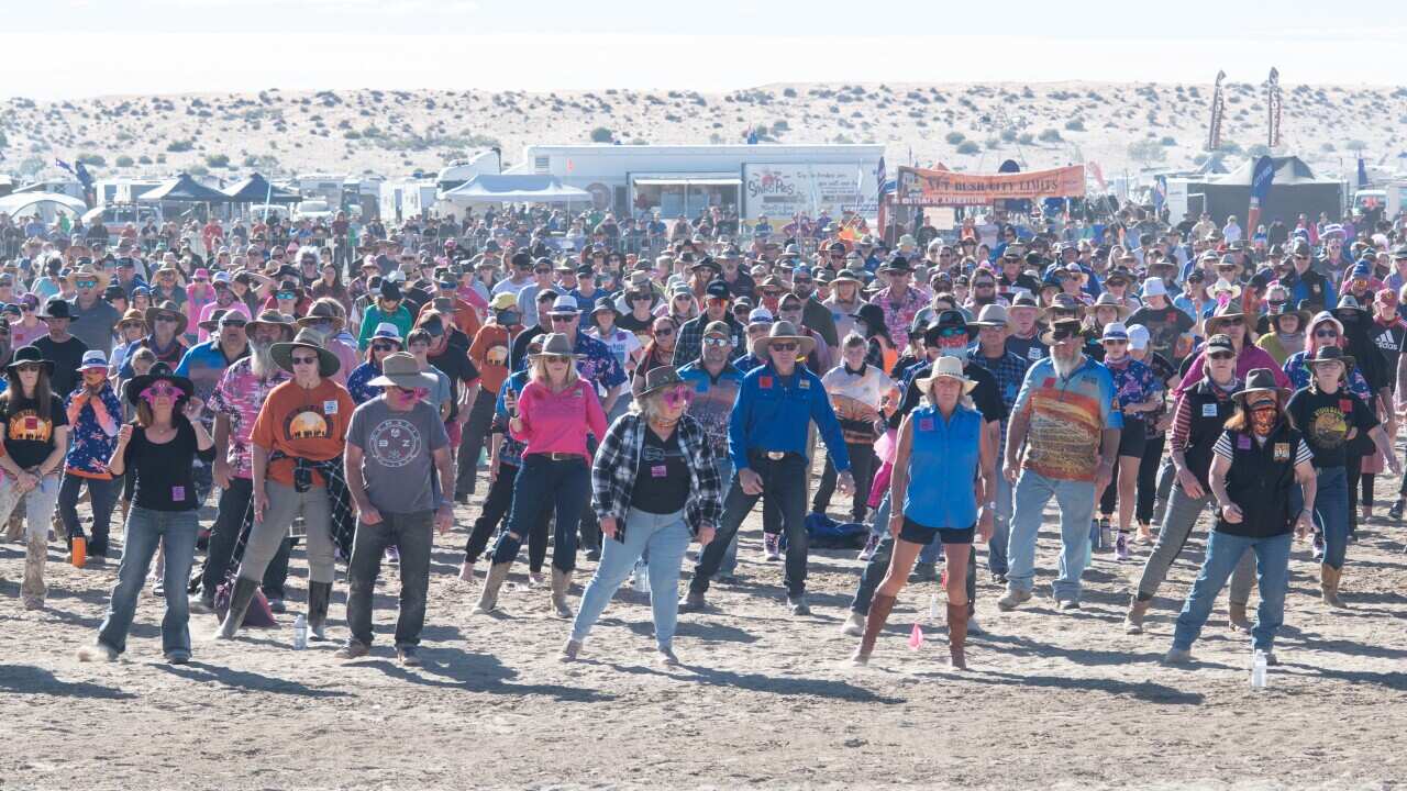 Hundreds of people doing the nutbush dance at a festival in Australia's outback.