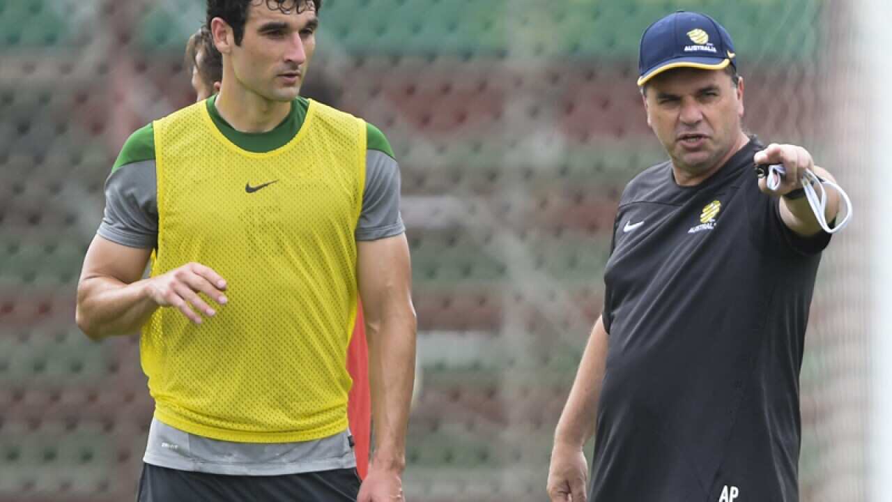 Socceroos coach Ange Postecoglou with skipper Mile Jedinak (L)