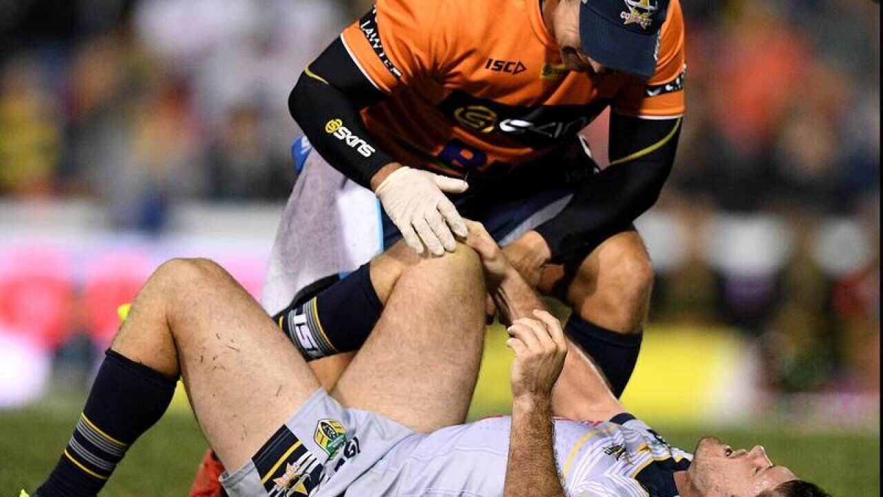 Lachlan Coote of the Cowboys receives attention from a trainer.