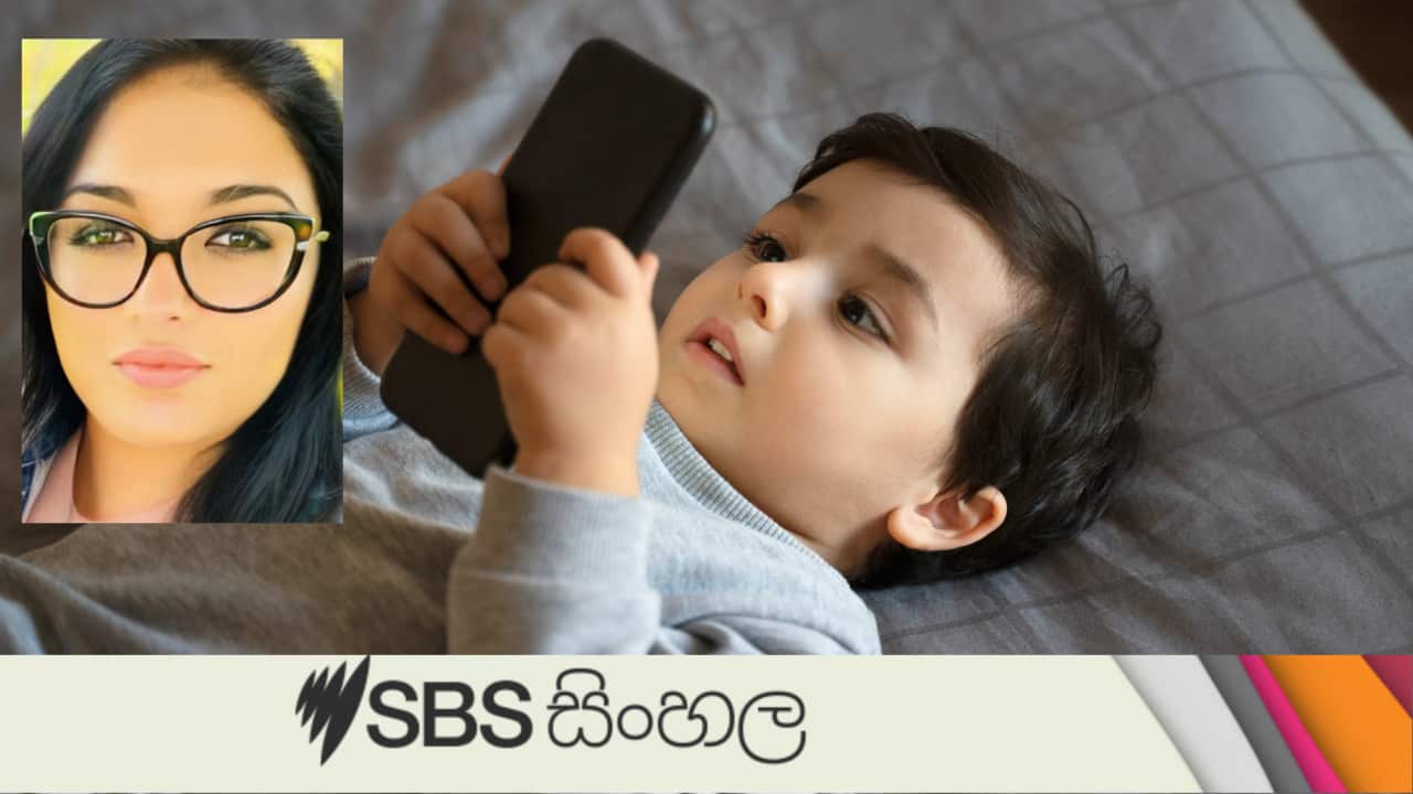 Cute toddler boy playing with a smartphone in bed