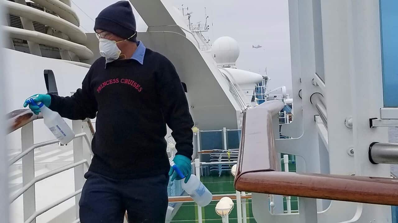 A cruise ship worker cleans a railing on the Grand Princess Thursday, March 5, 2020, off the California coast.