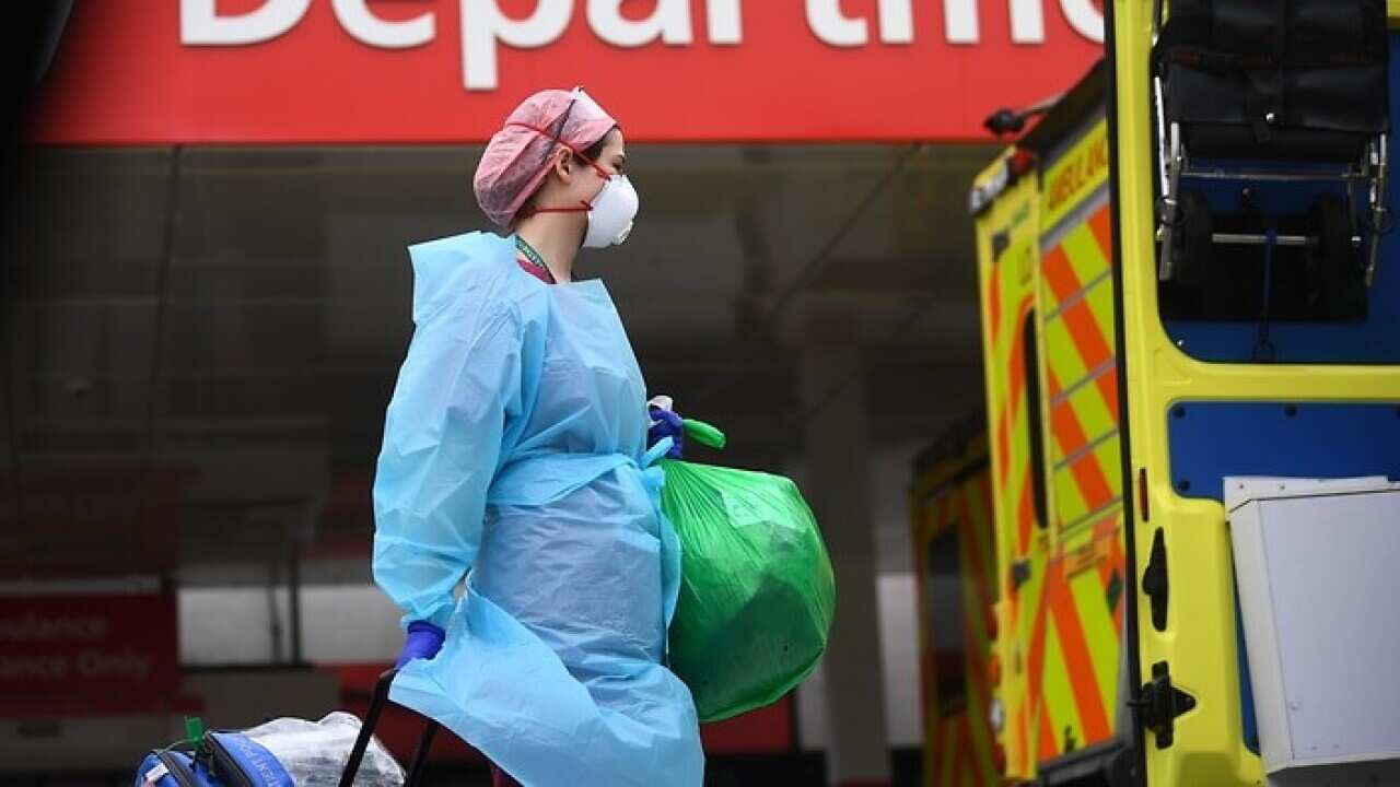A member of hospital staff wearing personal protective equipment outside St Thomas' Hospital in Westminster, London.