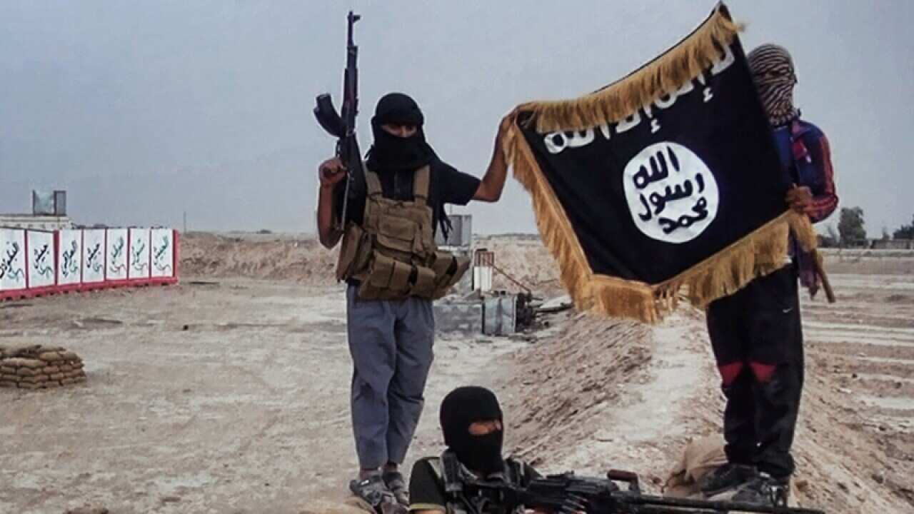 Militants pose with a jihadist flag after seizing an army checkpoint