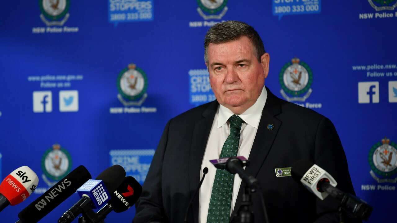 A man wearing a suit and tie speaking at a press conference