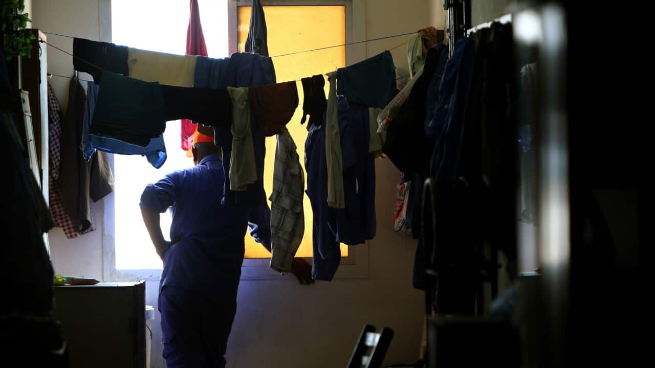 A worker from Nepal looks out from the window of his room at a private camp housing foreign workers in Doha