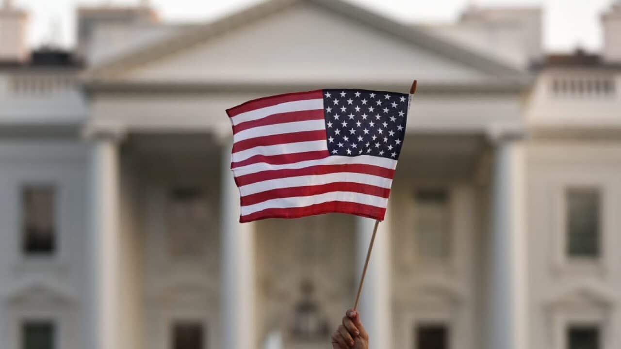A US flag is waved during an immigration rally outside the White House, in Washington, Sept. 2017