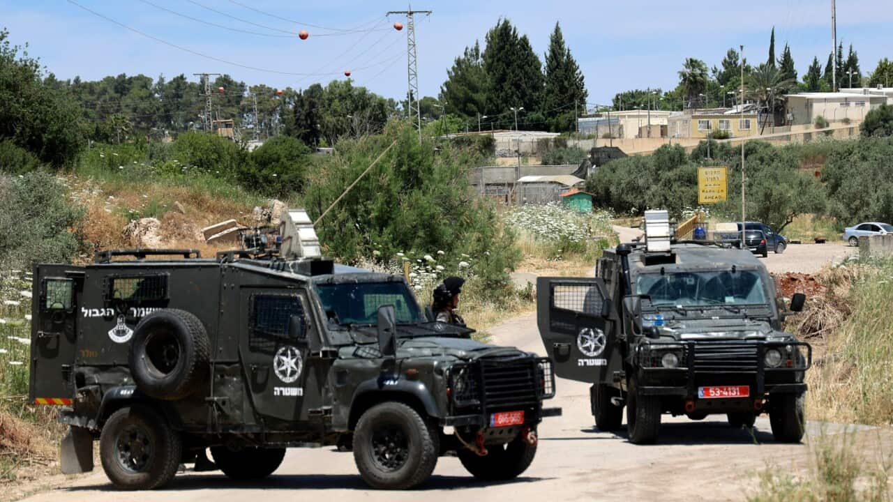 Jeeps belonging to Israeli security forces parked across as road in the West Bank