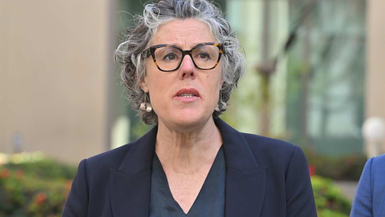 A woman with glasses talking.