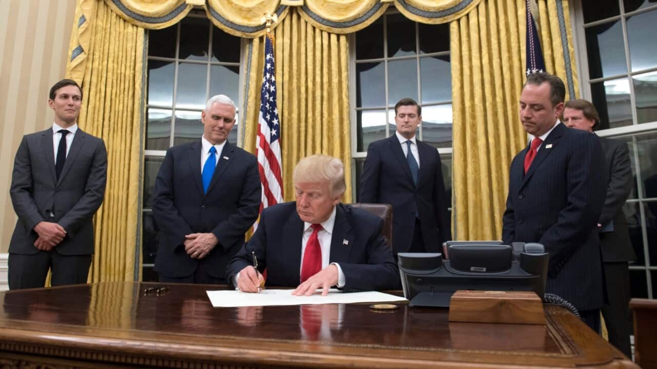 US President Donald J. Trump (C) speaks to members of the media