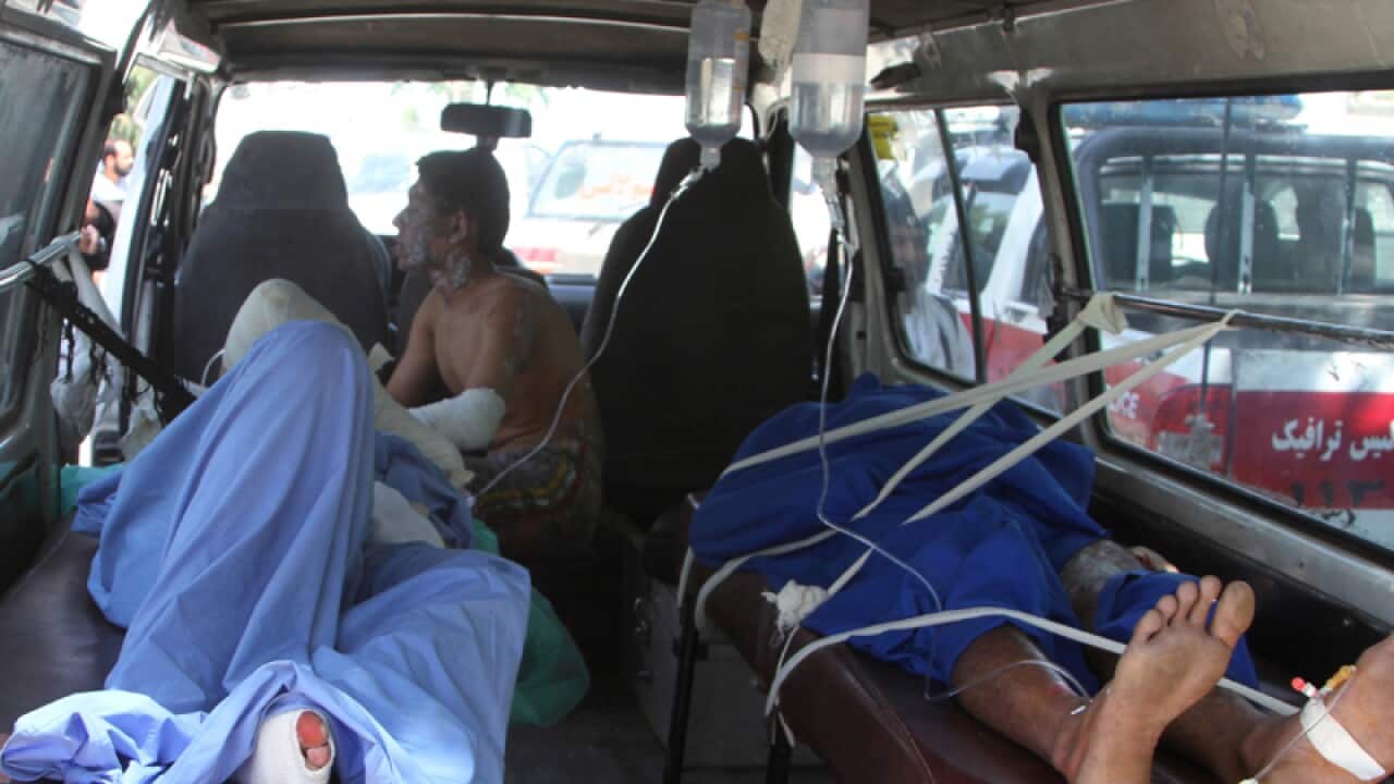 Injured Afghan men lie in an ambulance