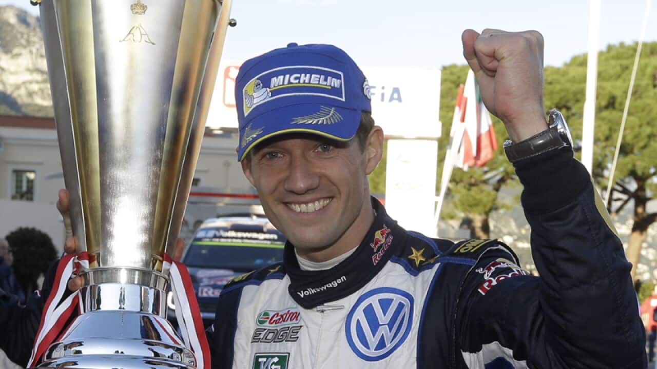 World champion Sebastien Ogier of France, raises his trophy