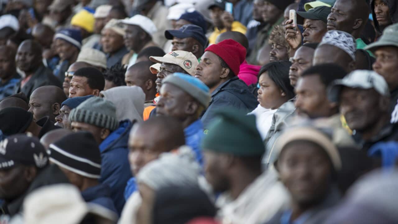 South African platinum miners sit during a rally