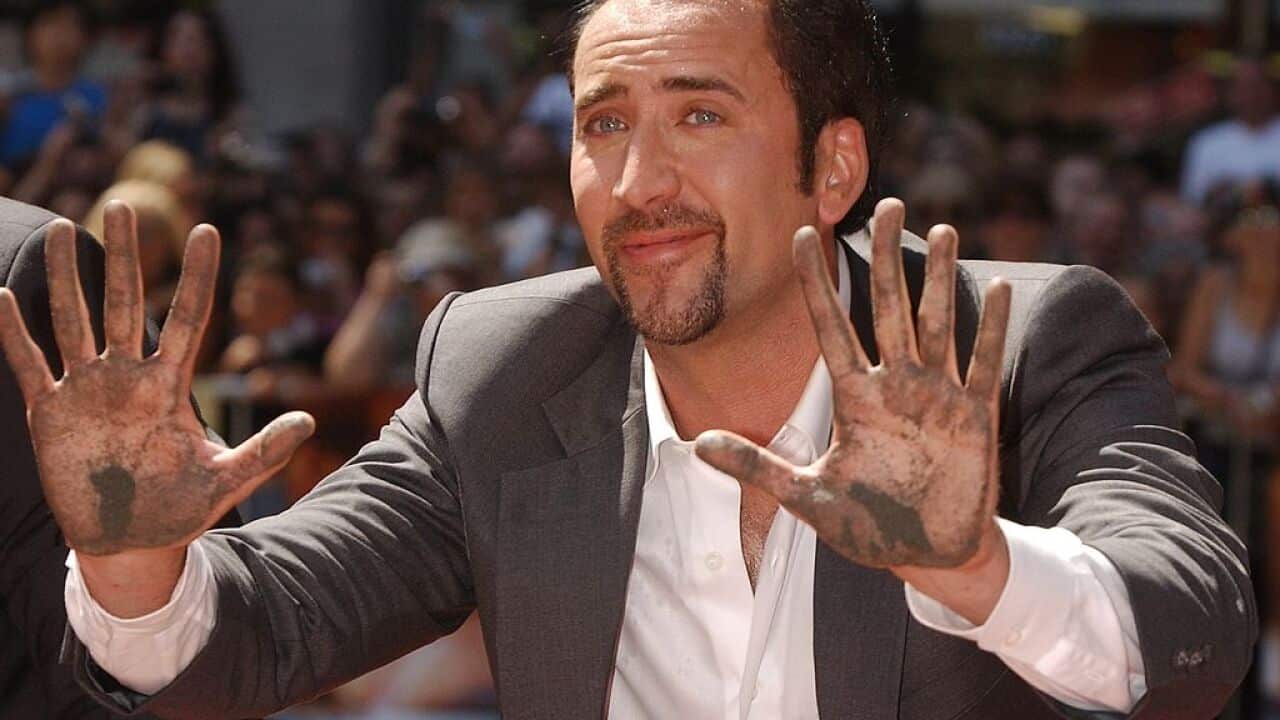 Actor Nicolas Cage raises his hands out of cement during a hand and footprint ceremony honoring him August 14, 2001 at the famous Grauman''s Chinese Theatre in Hollywood