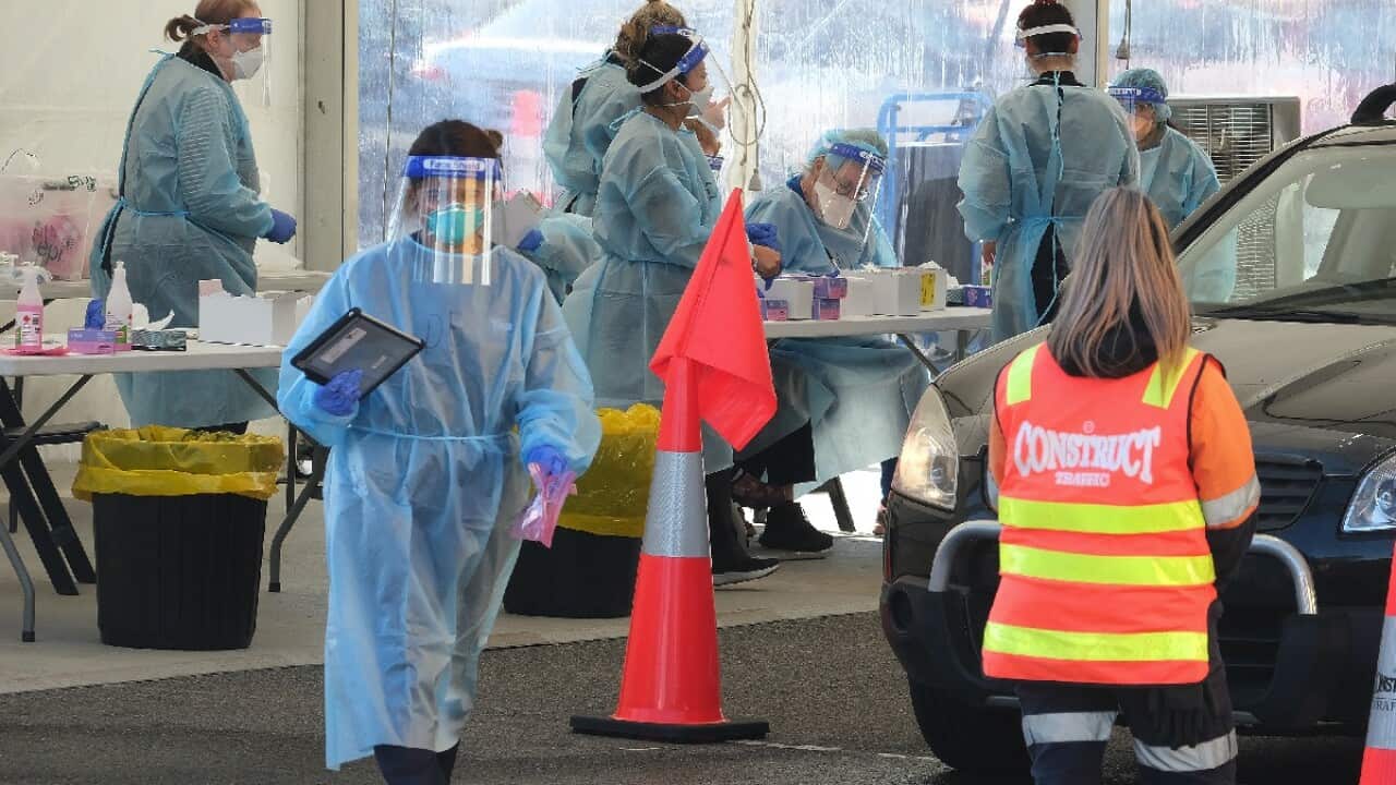 Health workers perform COVID-19 tests in the pop-up testing site outside the Palais Theatre in St Kilda, Melbourne