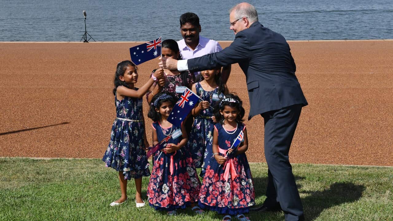 Prime Minister Scott Morrison hands out Australian flags at an Australia Day Citizenship Ceremony and Flag Raising event in Canberra, Saturday, January 26, 2019