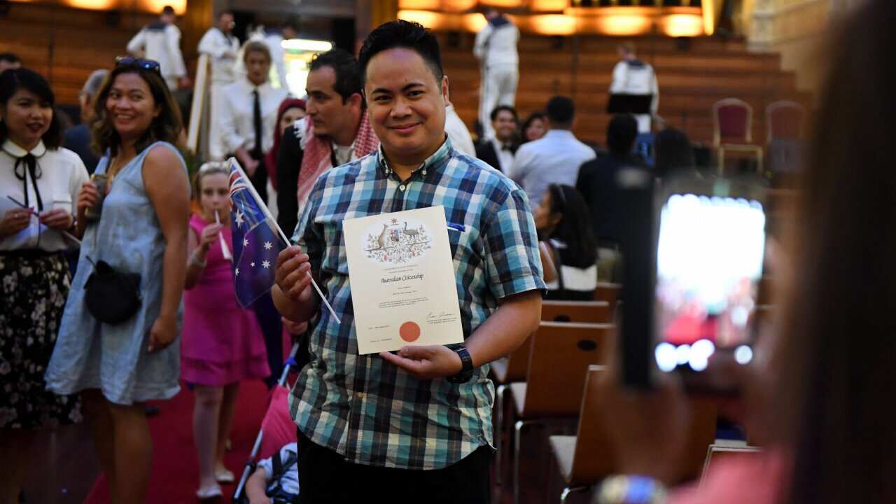 An Australian citizenship recipient poses for a photo after a citizenship ceremony on Australia Day in Brisbane, Thursday, Jan. 26, 2017. (AAP Image/Dan Peled) NO ARCHIVING