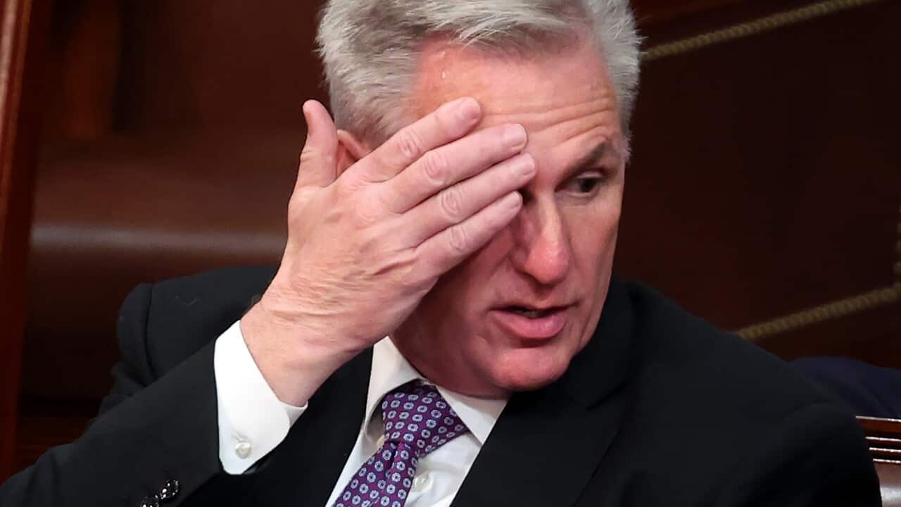 A man wearing a suit and tie who is seated in the US House of Representatives.