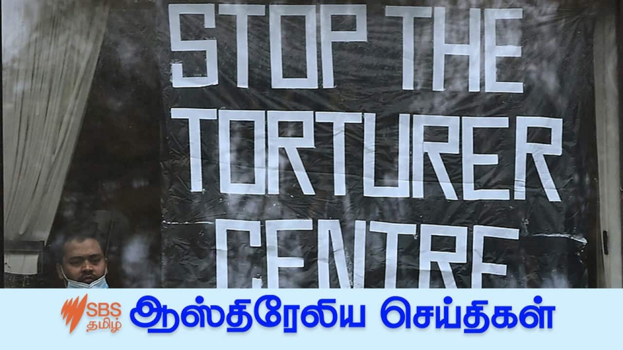 A man looks out after placing a banner in the window of his room at Melbourne's Park Hotel, where tennis world No.1 Novak Djokovic is also being detained.
