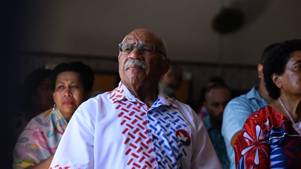 A man wearing glasses and a colourful shirt attends a church service in Fiji.
