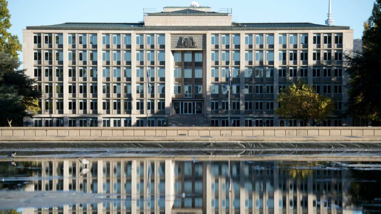 The Department of Treasury is seen reflected in a fountain in Canberra