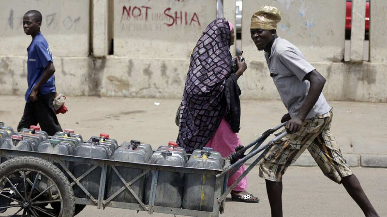 A man pushes water bottles in Kano, Nigeria