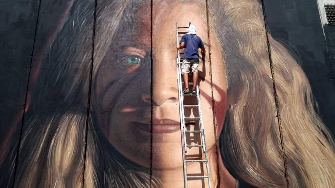 Italian Artist Jorit painting a portrait of Ahed Tamimi
