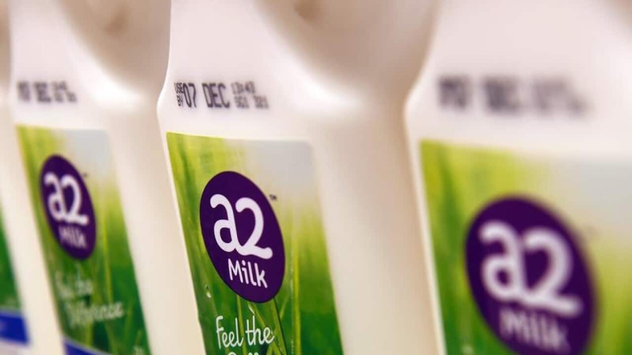 Bottles of A2 milk are displayed in a fridge.